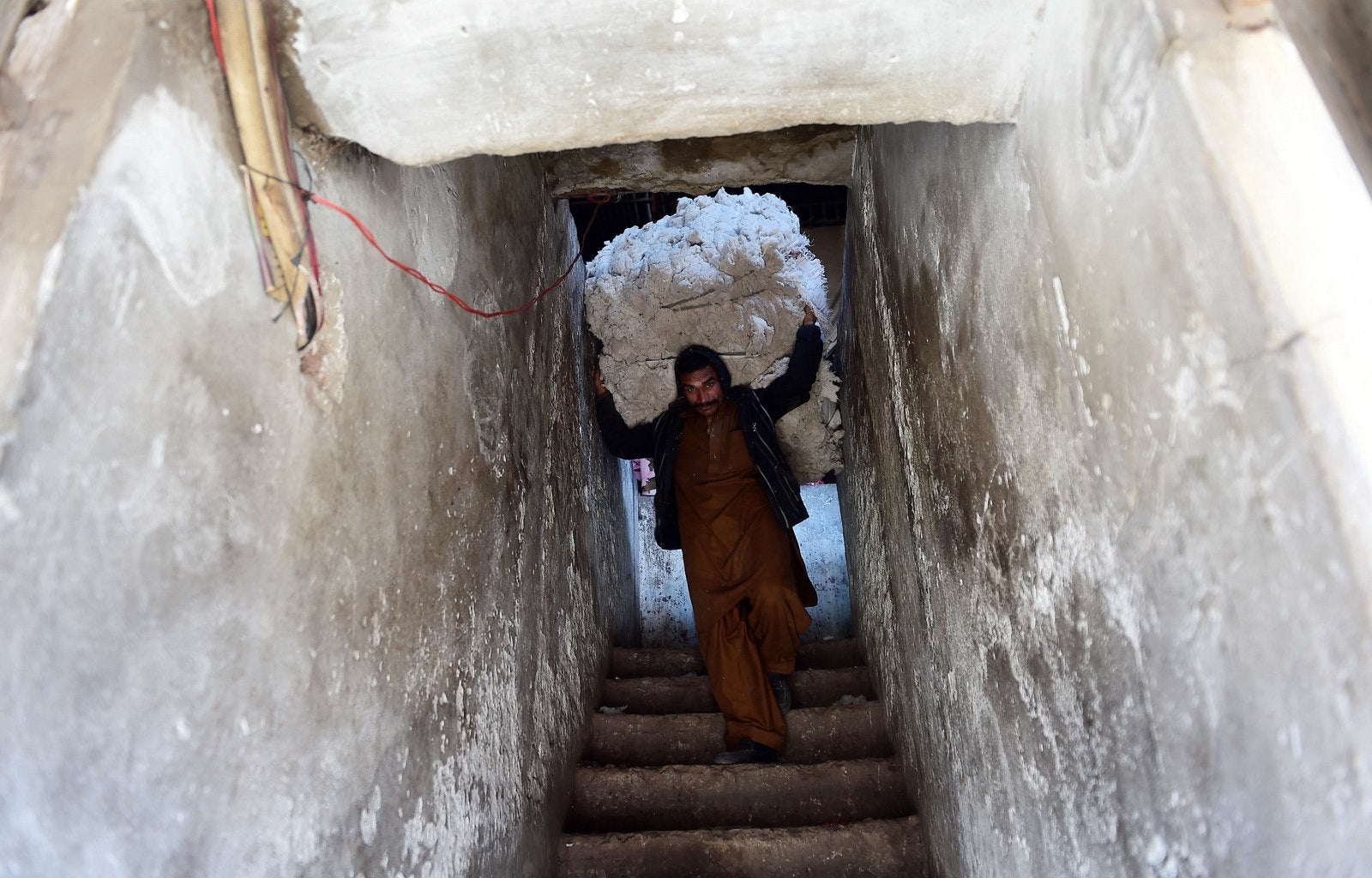 Un trabajador paquistaní transporta un paquete de algodón en una tienda de un mercado en Rawalpindi.