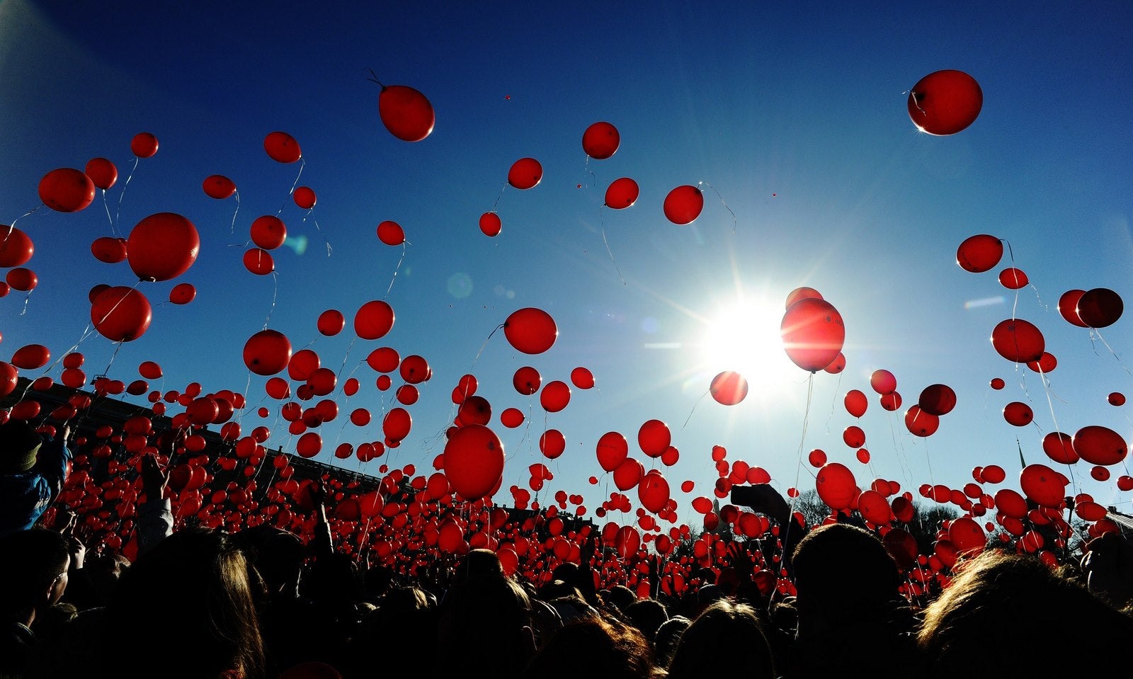 Un grupo de gente liberan globos rojos durante un flashmob en la Plaza de San Petersburgo .