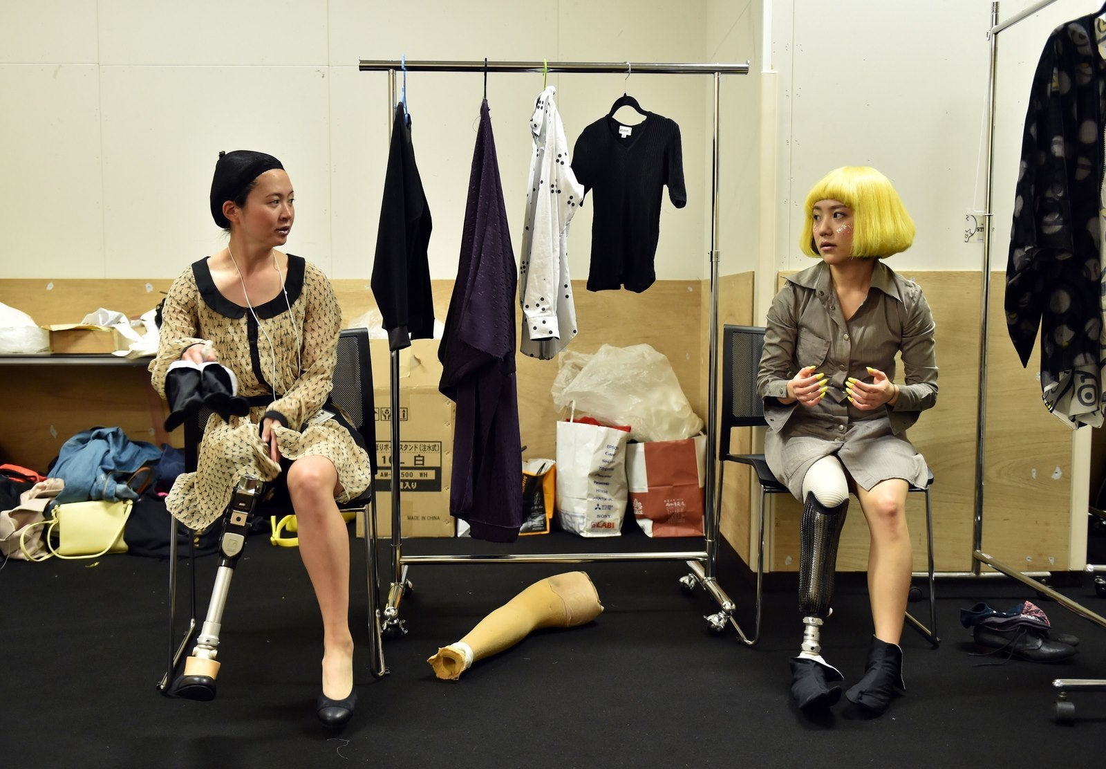 TOPSHOTS Los atletas paralimpicos Sayaka Murakami (L) y Mika Abe (R) conversan mientras esperan detrás del escenario para participar en un desfile de moda de la marca "Tenbo".