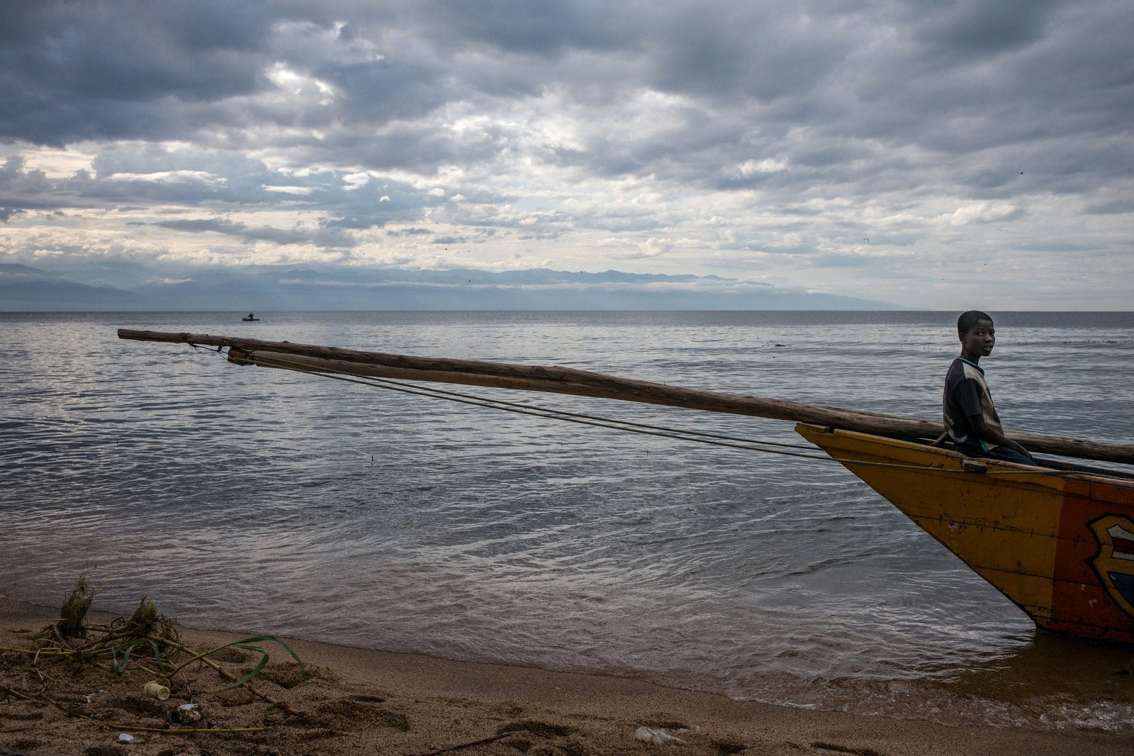 Un joven pescador congolés se sienta en la proa de un barco atracado en el lago Tanganika en Uvira.