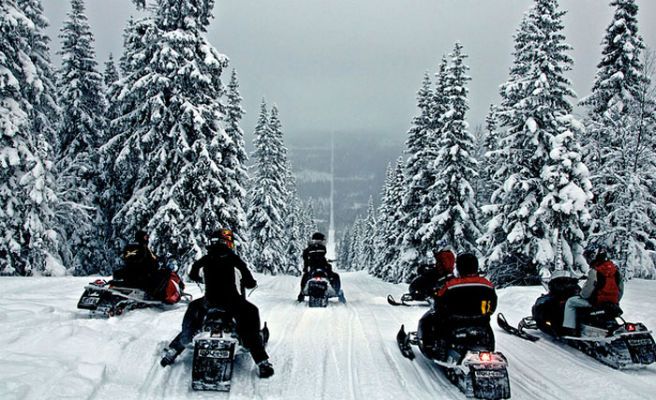 NORUEGA Y SUECIA. En plena nieve, un enorme camino por el que suelen pasar motos adaptadas marca la frontera entre Noruega y Suecia. El sendero permanece bloqueado por una gran cantidad de árboles a cada lado.