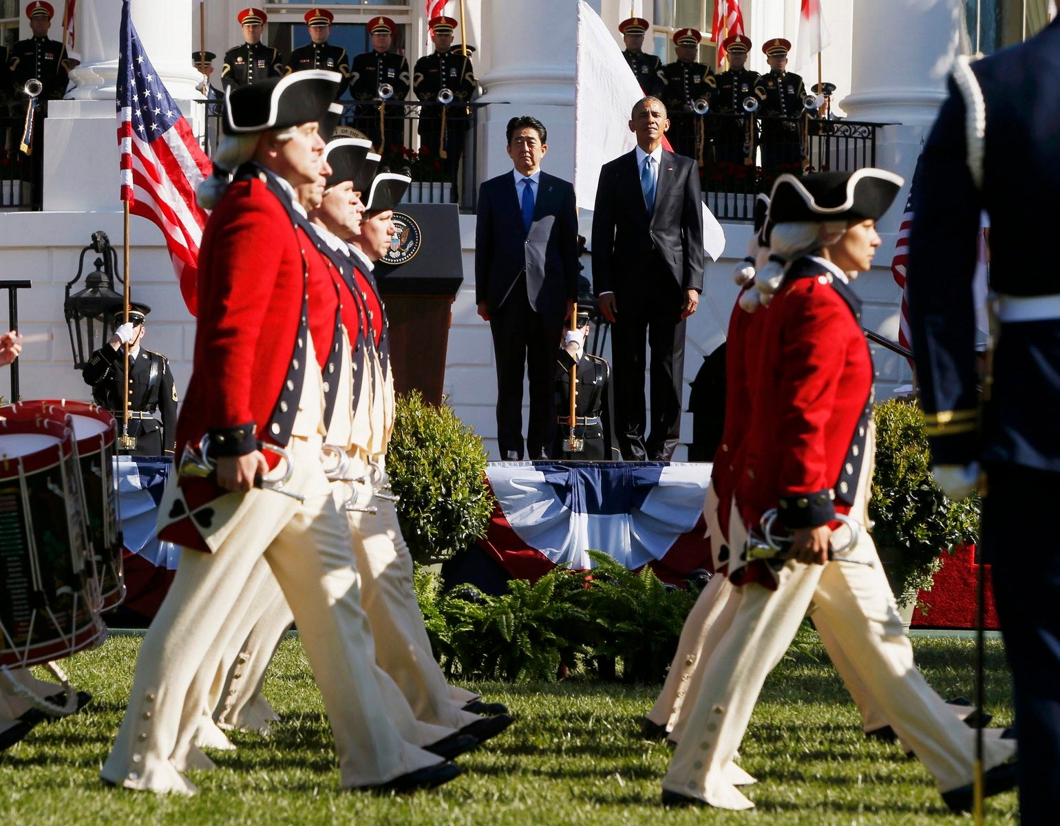 Los miembros de la marcha Vieja Guardia del Ejército de EE.UU. Fife y Drum Corps pasado el presidente estadounidense, Barack Obama (R) y el primer ministro japonés, Shinzo Abe, durante una ceremonia de llegada oficial del primer ministro japonés, Shinzo Abe, en la Casa Blanca.