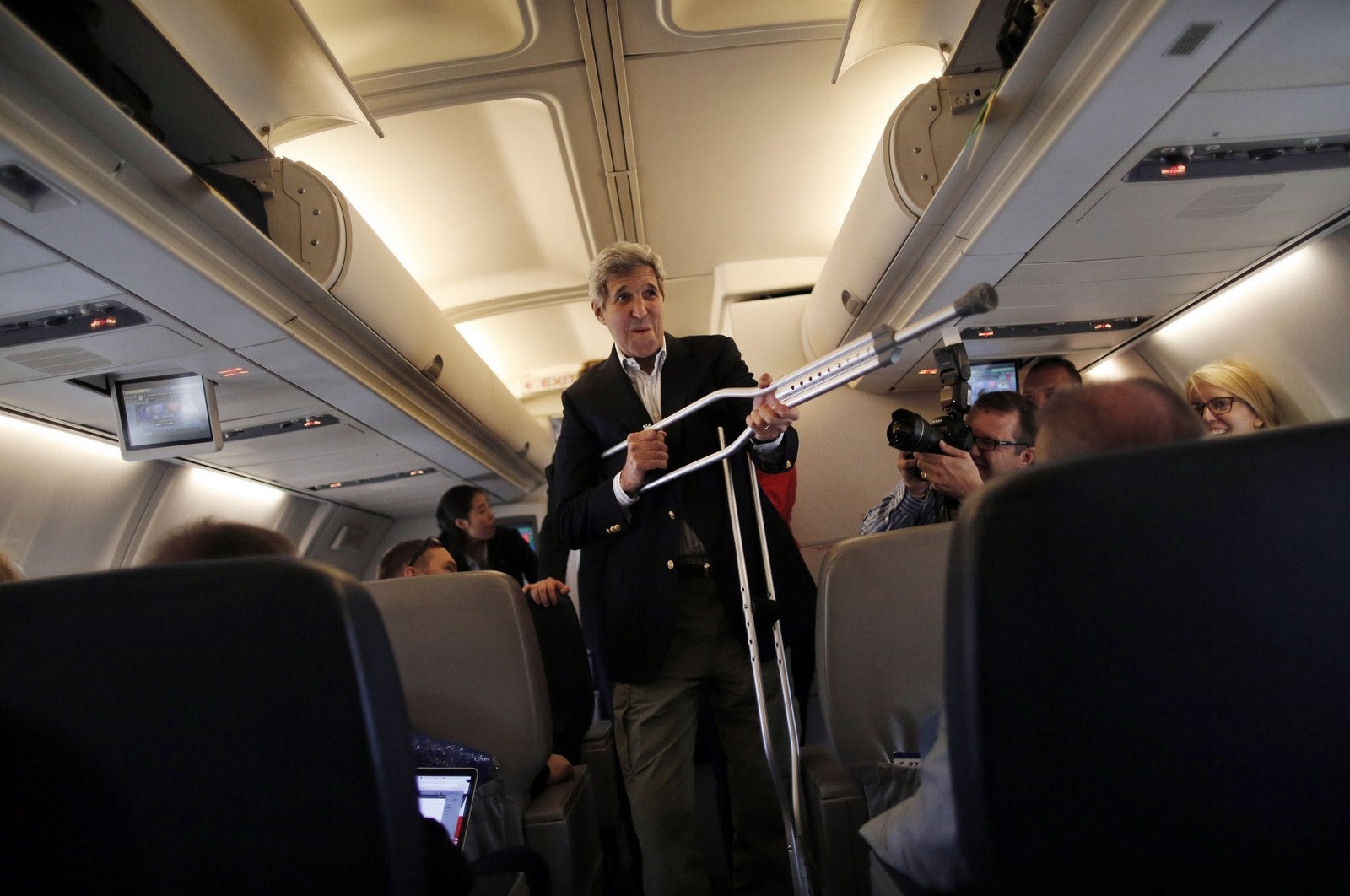 John Kerry, juega con sus muletas mientras habla con los reporteros antes de partir para Viena, Austria.