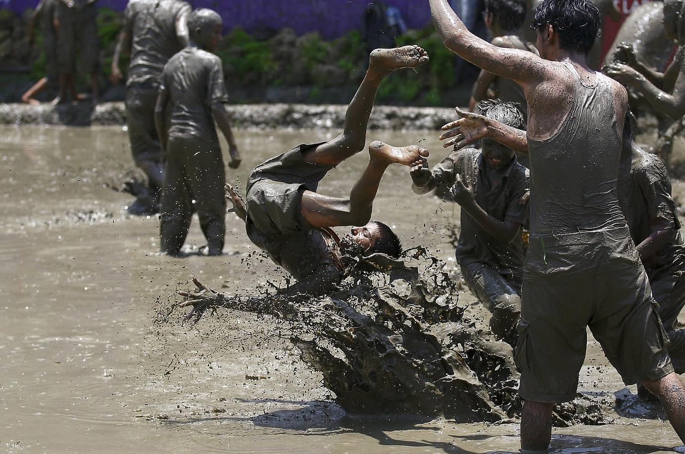 Un muchacho es tirado a el lodo durante el festival Asar Pandhra en el valle de Pokhara, al oeste de la capital de Nepal, Katmandú. Los agricultores en Nepal celebra el festival con motivo del inicio de la siembra de los cultivos de arroz en los arrozales.