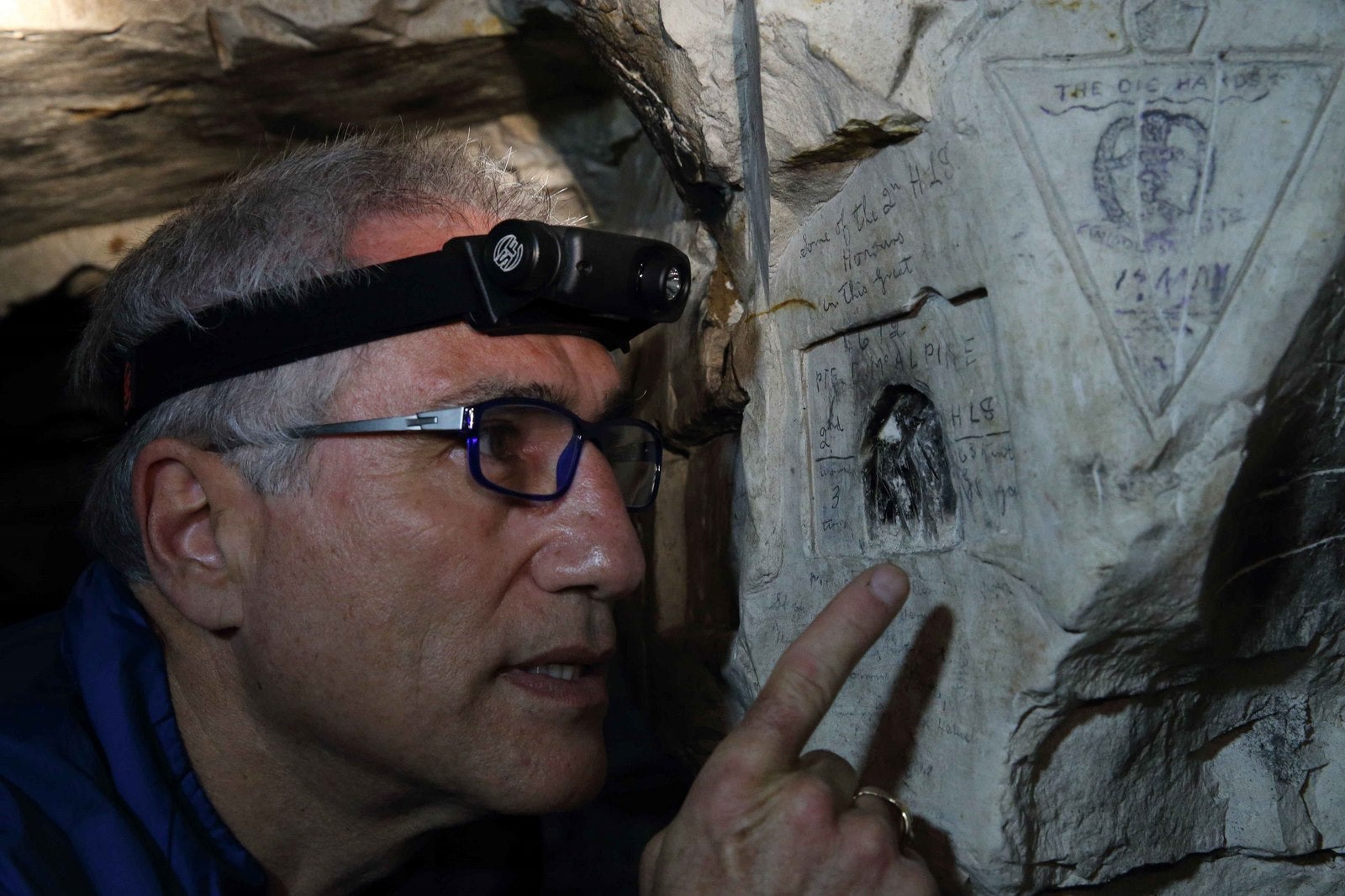 Jeffrey Gusky, un médico estadounidense que durante los últimos 20 años ha reunido las imágenes para un proyecto fotográfico llamado "The Hidden World de la Primera Guerra Mundial", mira a las inscripciones por parte de soldados en cuevas subterráneas accesibles por pequeñas escaleras de caracol en la iglesia del pueblo en Bouzincourt, norte Francia.