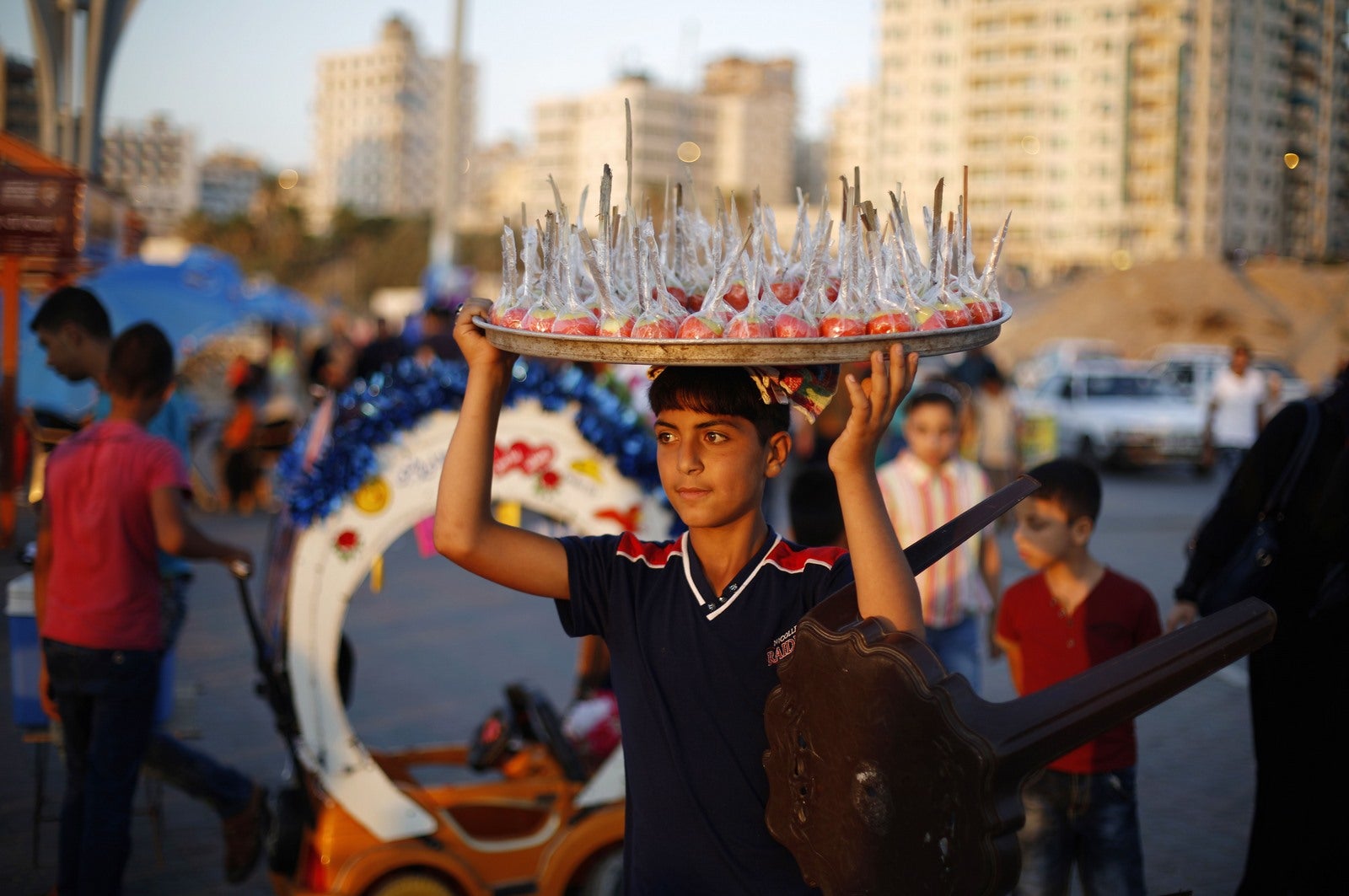 Un vendedor ambulante palestino vende manzanas de caramelo en el puerto de mar en la ciudad de Gaza.