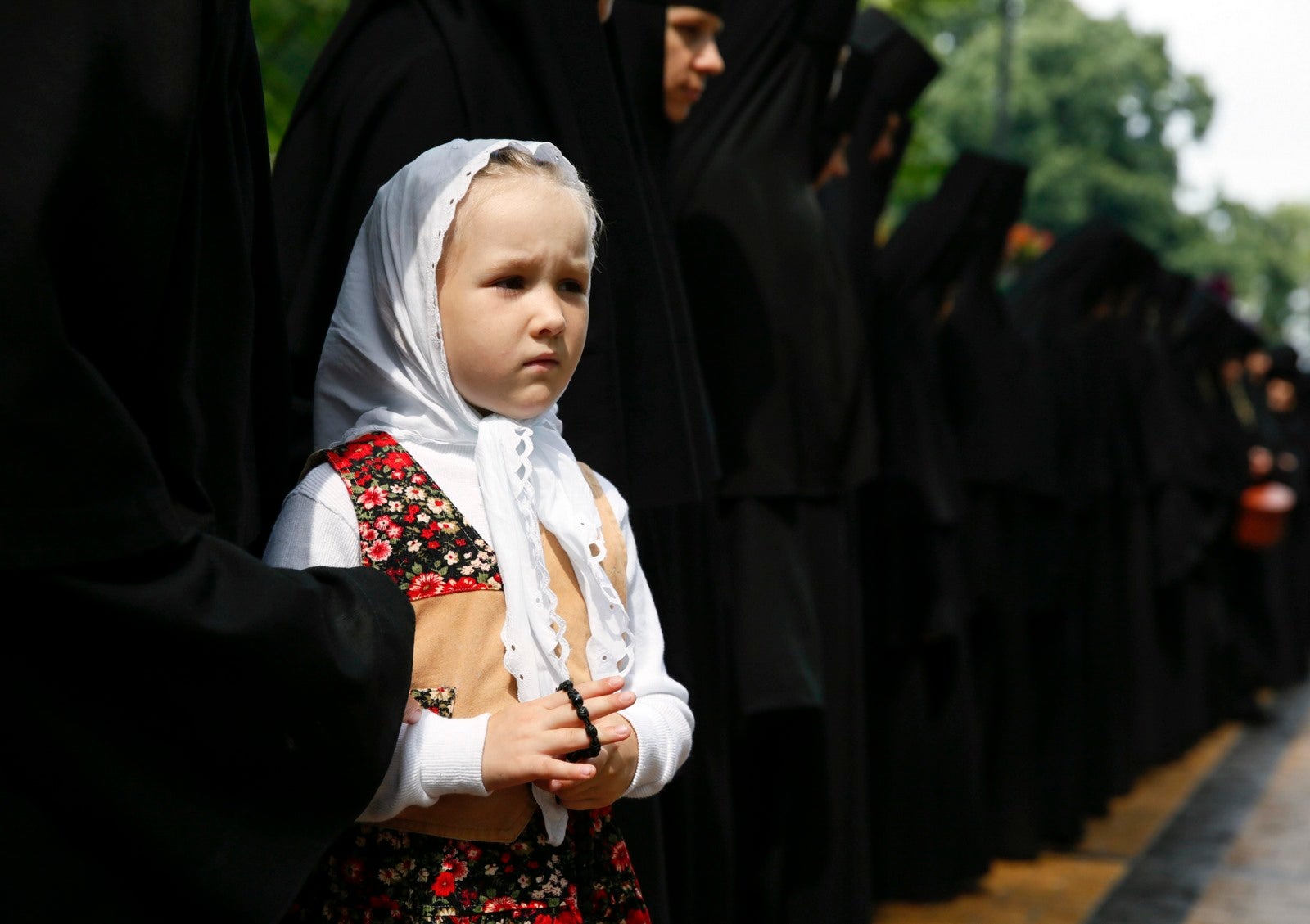 Una niña al lado de monjas durante una ceremonia para conmemorar el 1000 aniversario de la muerte de Vladimir el Grande en Kiev.
