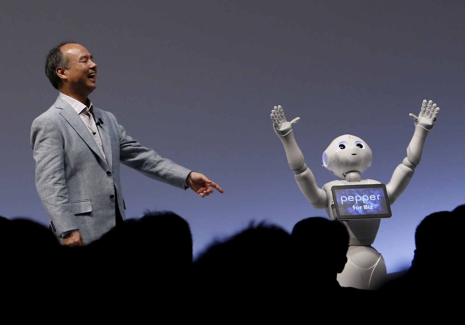 Presidente SoftBank Group Corp. y CEO Masayoshi Son reacciona con el robots de apariencia humana de SoftBank nombrados "Pimienta" durante el evento SoftBank Mundial 2015 en Tokio, Japón.
