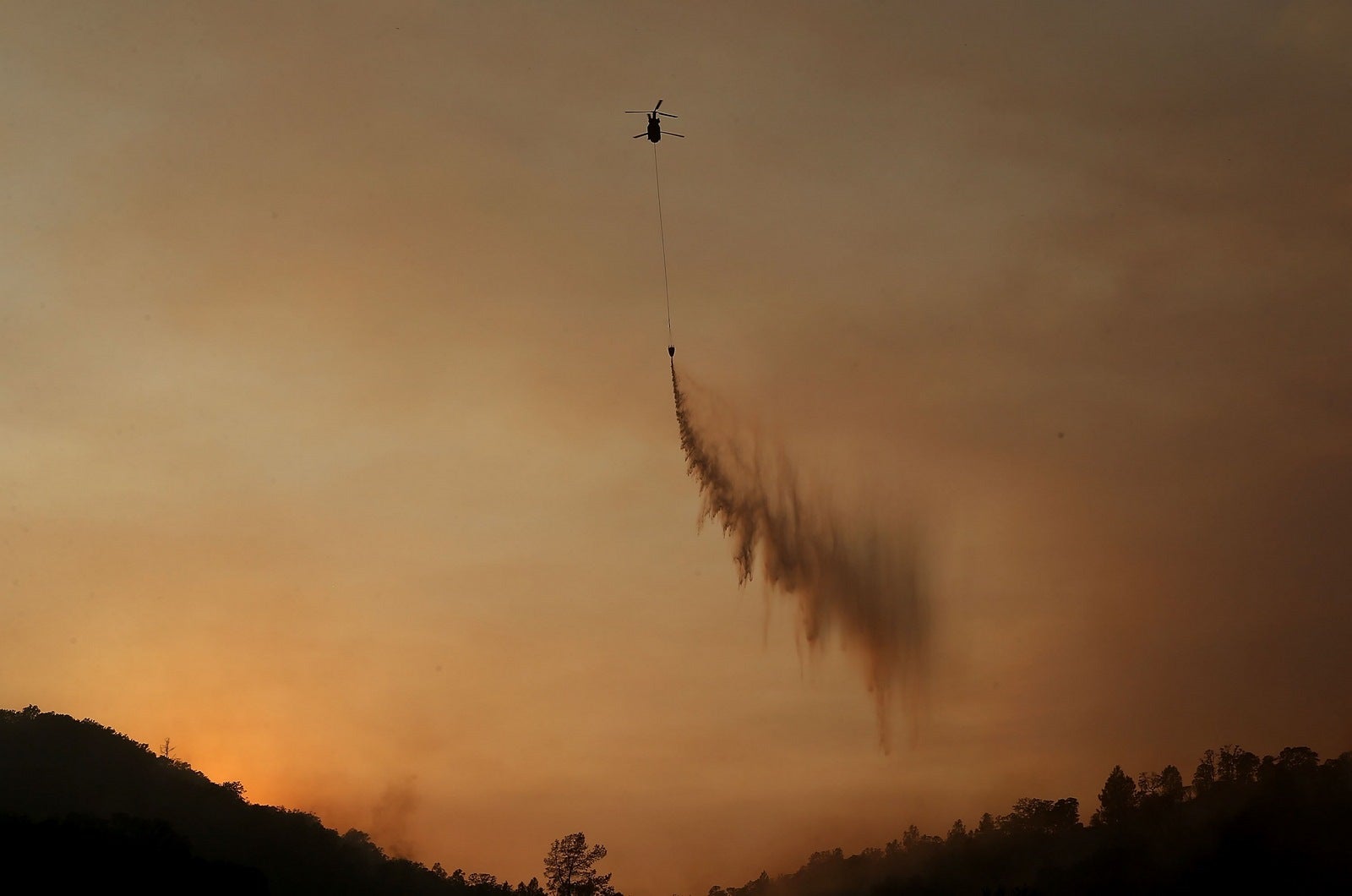 Un helicóptero de extinción de incendios lucha contra el Fuego Rocky, California.