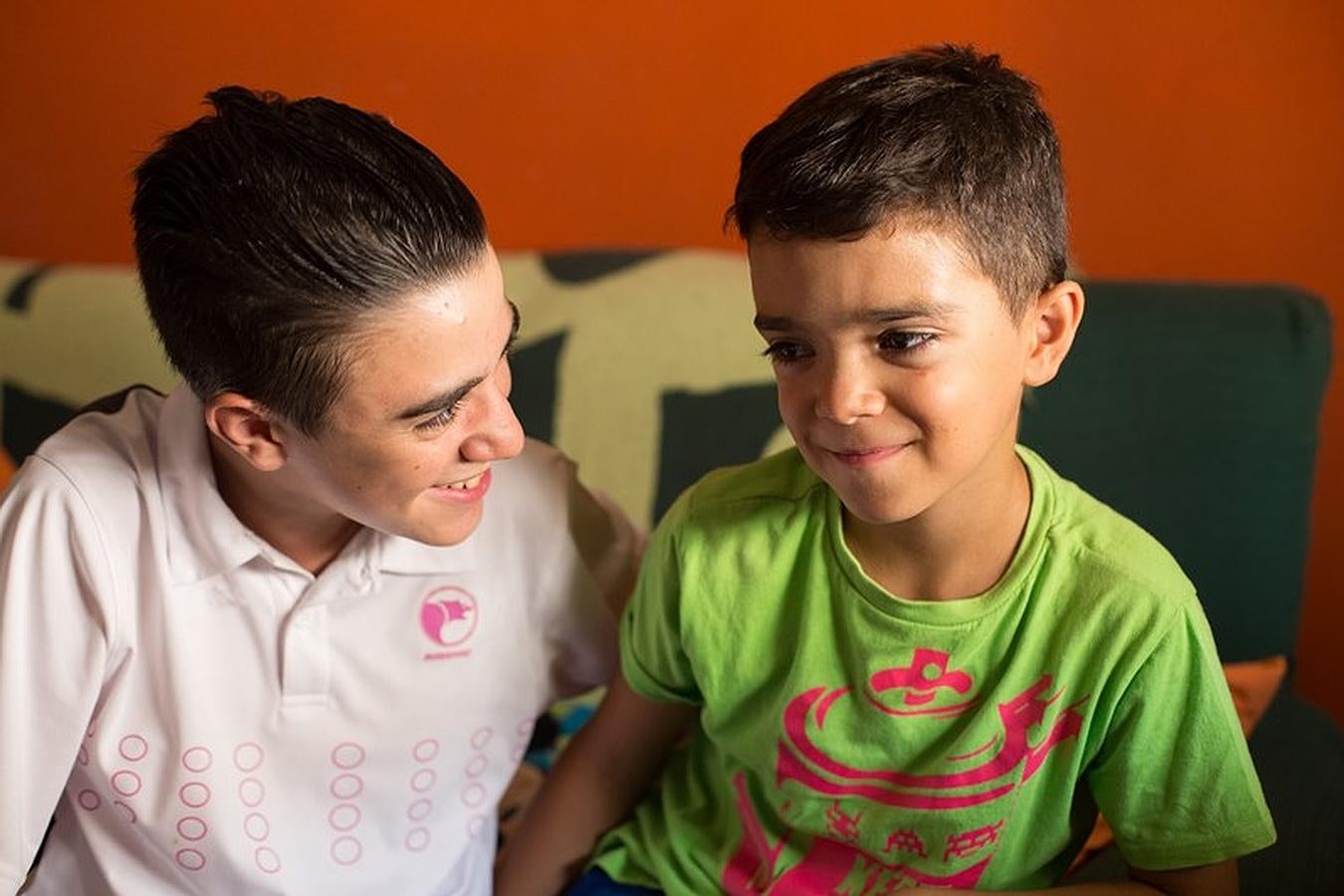 Miguel mira a David en el salón de su casa.