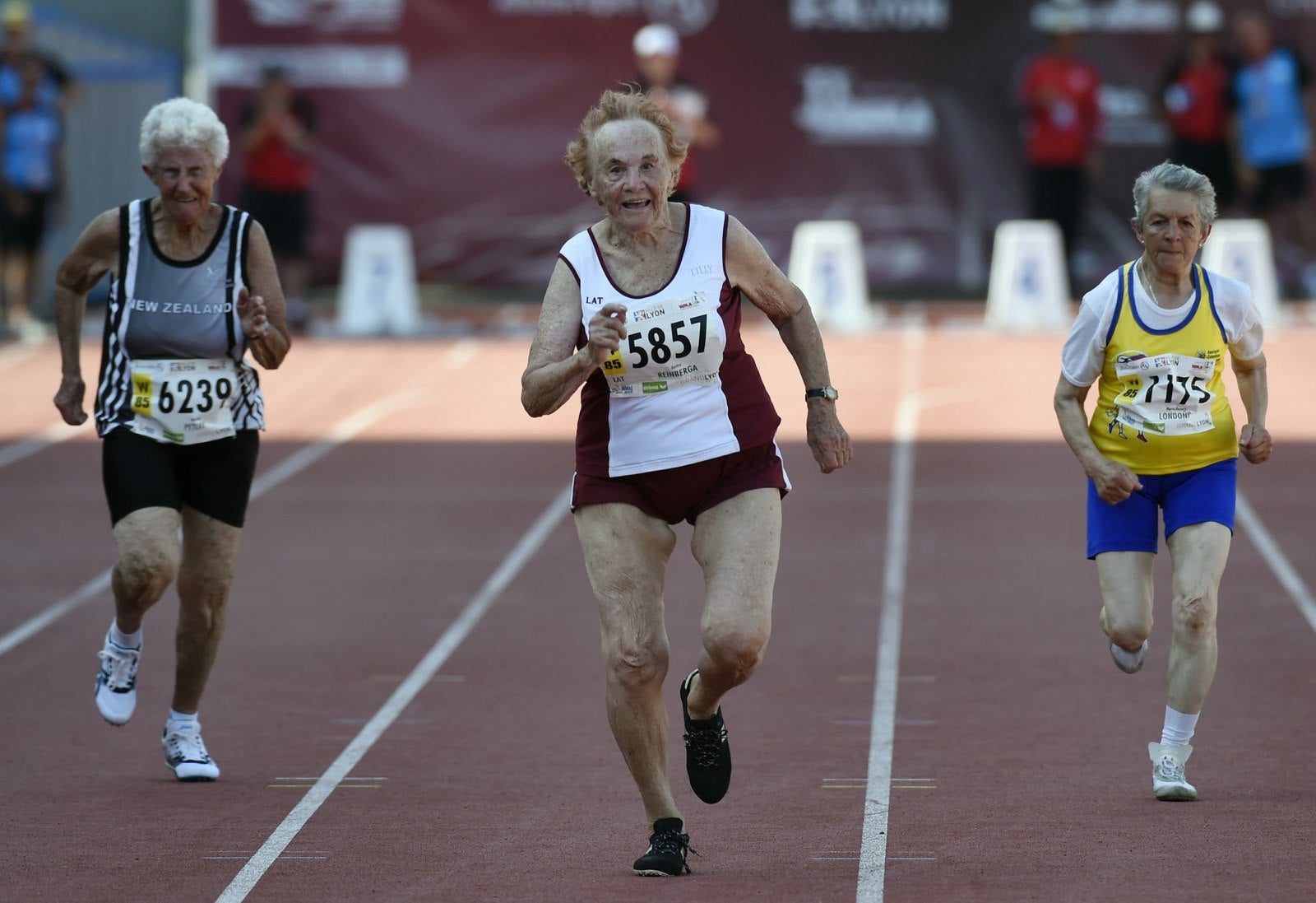 La lituana Austra Reinberga (C) corre junto a Marcia Petley de Nueva Zelanda (L) y María Pastora Londoño de Colombia (R) durante la final femenina de 100 metros para atletas entre 85 y 89 años de edad.