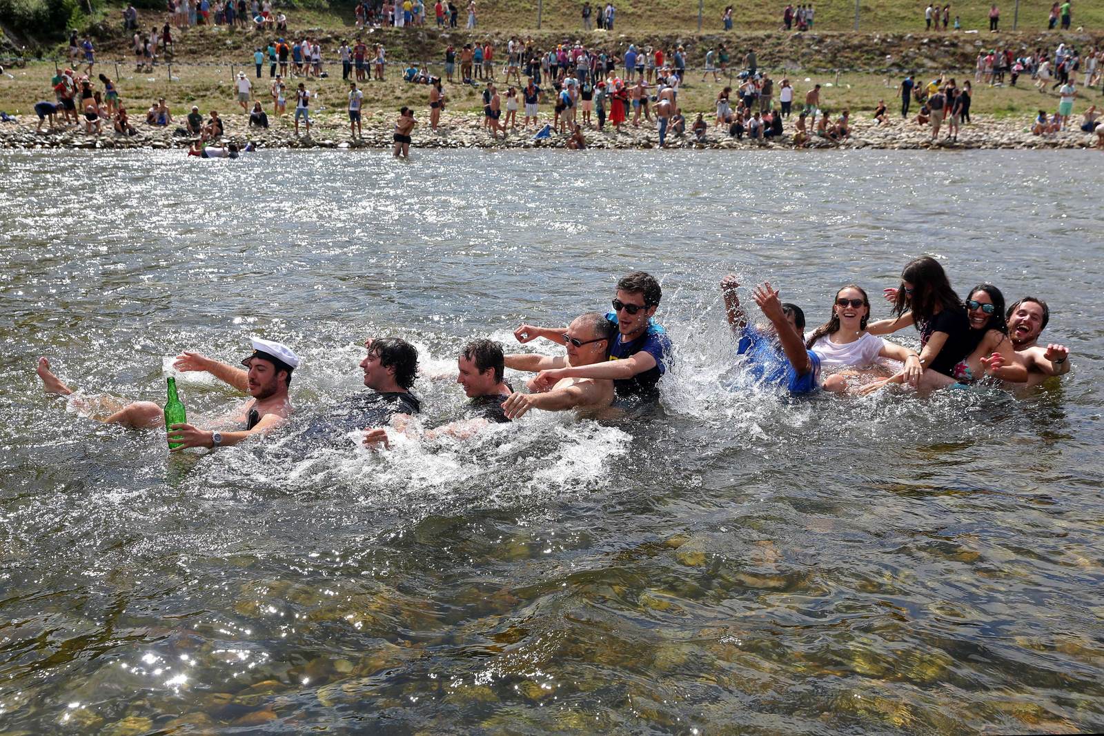 Espectadores juegan en el río después del inicio de la 79 edición del "Descenso Internacional del Río Sella 2015".