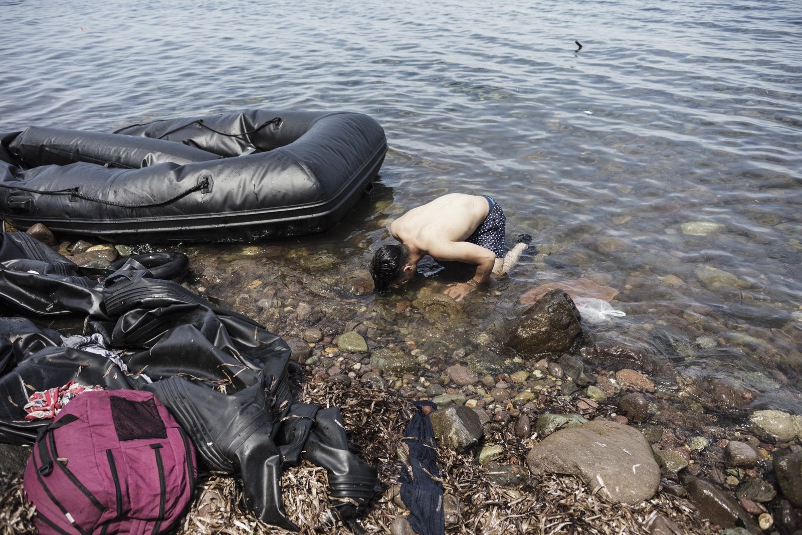 Un hombre sirio besa la tierra después de llegar a las costas de la isla griega de Lesbos tras cruzar el mar Egeo desde Turquía a Grecia.