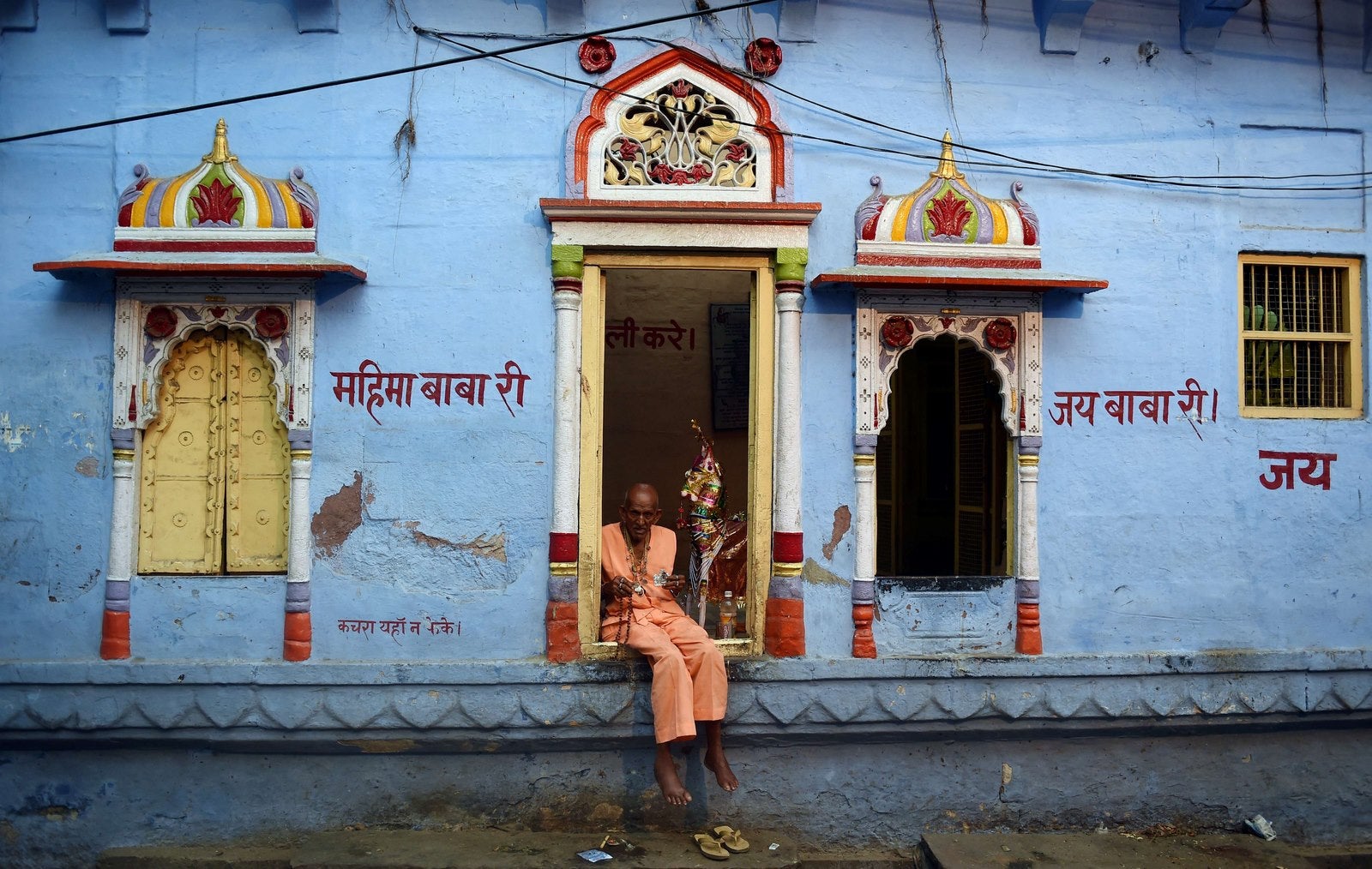 Un hombre indio sentado a la puerta de un templo en Jodhpur .