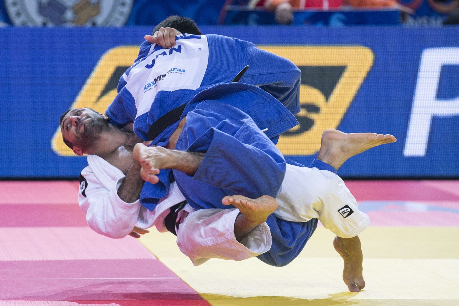 El azerbaiyán Nijat Shikhalizada (blanco) compite con el canadiense Antoine Bouchard durante el combate de clasificación, en la categoría de 66kg en el Campeonato Mundial de Judo en Astana.