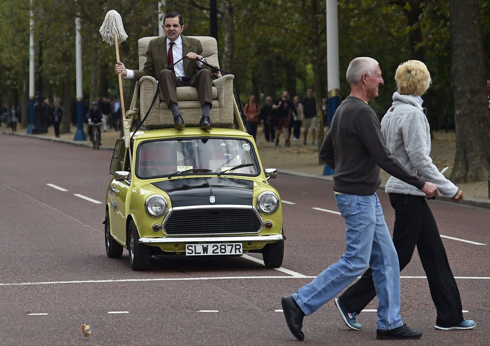 Comediante británico Rowan Atkinson, 'Mr Bean', monta en un coche Mini a lo largo del centro comercial en el centro de Londres.