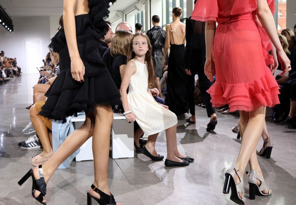 Una niña mira como las modelos presentan unos diseños de Jason Wu durante la Semana de la Moda de Nueva York.