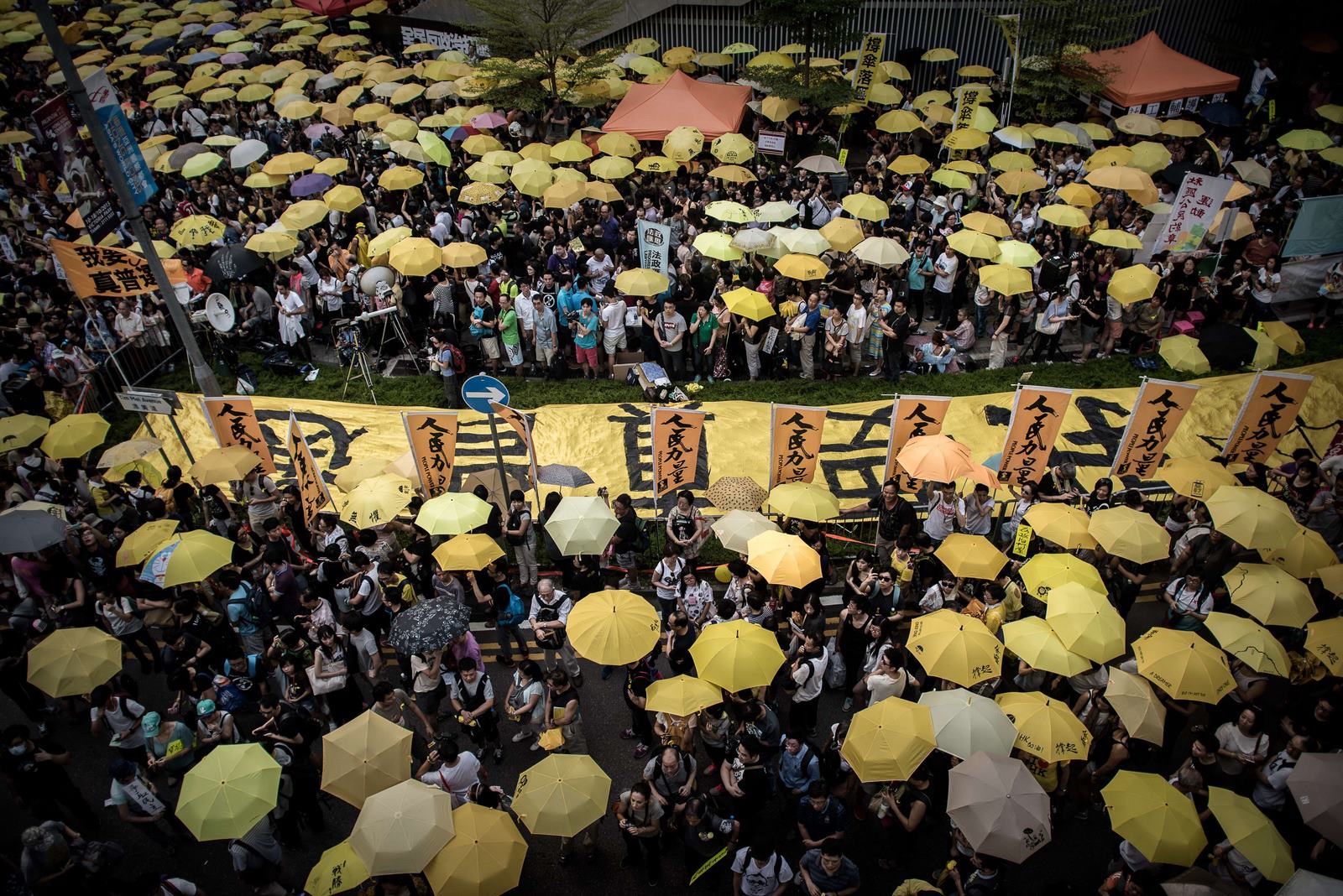 Manifestantes y activistas pro-democracia se reúnen fuera del edificio de la sede del gobierno para conmemorar un año desde el inicio de los medios de mítines pro-democracia que piden elecciones libres en Hong Kong.