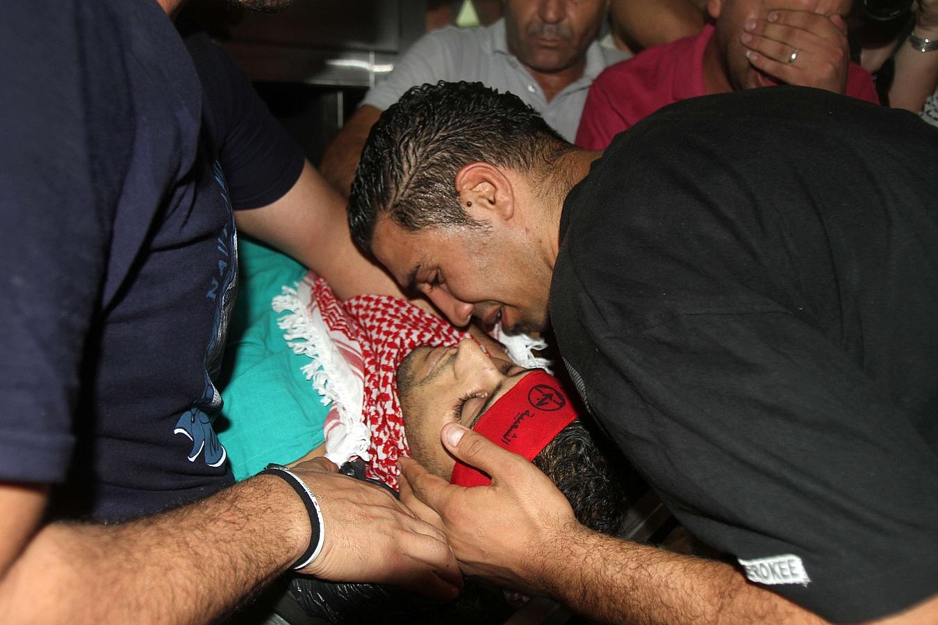 Los familiares lloran sobre el cuerpo de Moataz Zawahra, de 28 años, quien fue muerto en enfrentamientos con las fuerzas de seguridad de Israel.