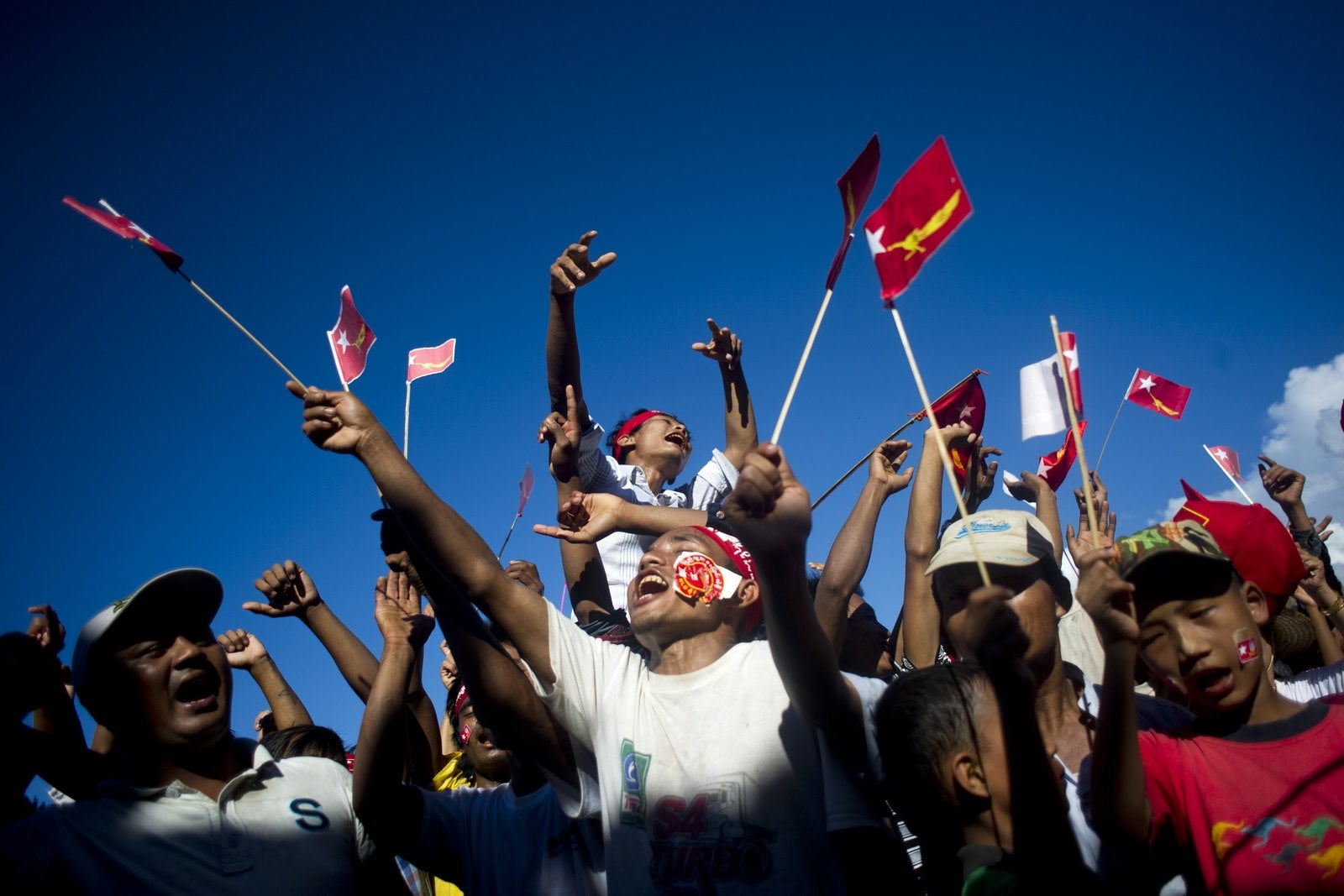 Partidarios ondean banderas mientras esperan la llegada de la Liga Nacional para la Democracia presidente Aung San Suu Ky.