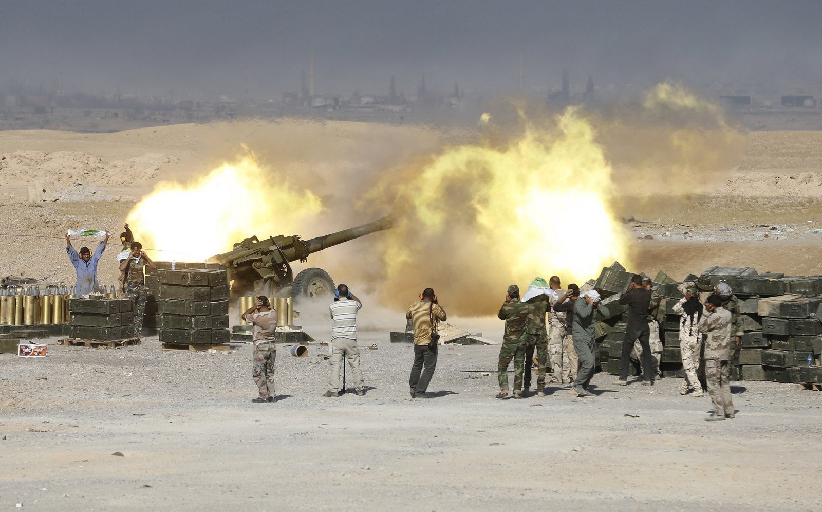 Combatientes chiítas lanzan artillería hacia militantes estado islámico en al-Fatha, al noreste de Baiji.