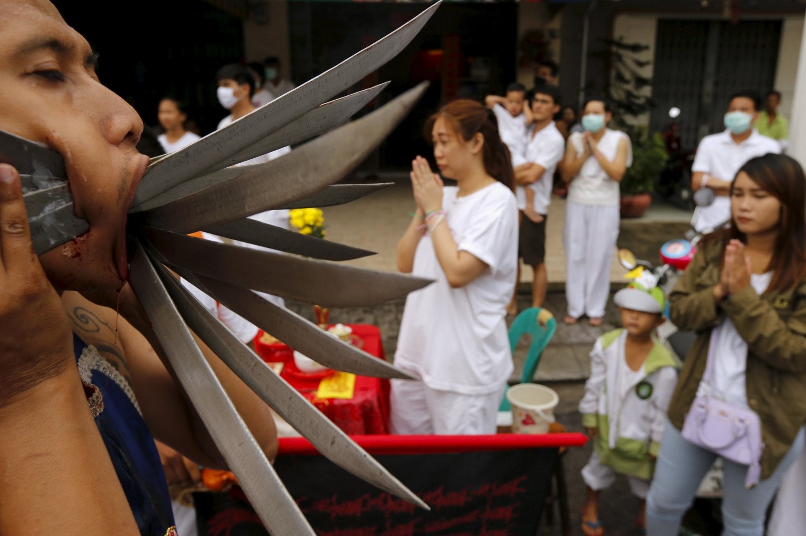 Un devoto con cuchillos perforados a través de sus mejillas camina durante una procesión que celebra el festival vegetariano anual en Phuket, Tailandia.