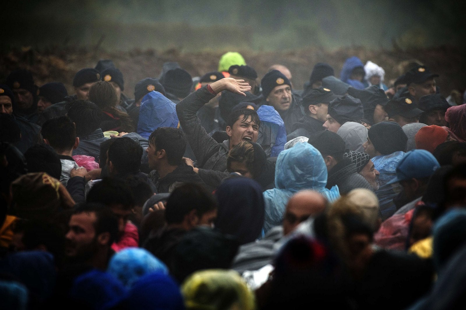 Policías croatas montan guardia mientras los inmigrantes esperan para entrar en Croacia desde la frontera entre Serbia y Croacia, cerca del pueblo de Serbia occidental de Berkasovo.