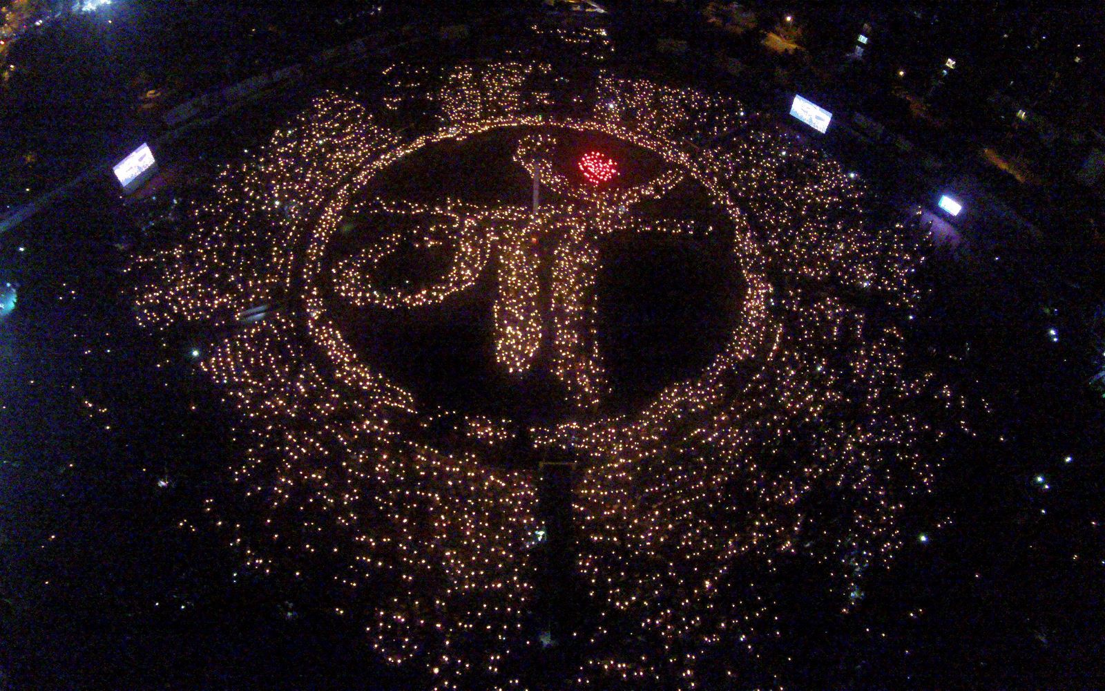 Artistas indios sostienen lámparas de aceite encendidas en la formación de la palabra madre en la sede del Foro Cultural Gandhinagar en Gandhinagar.