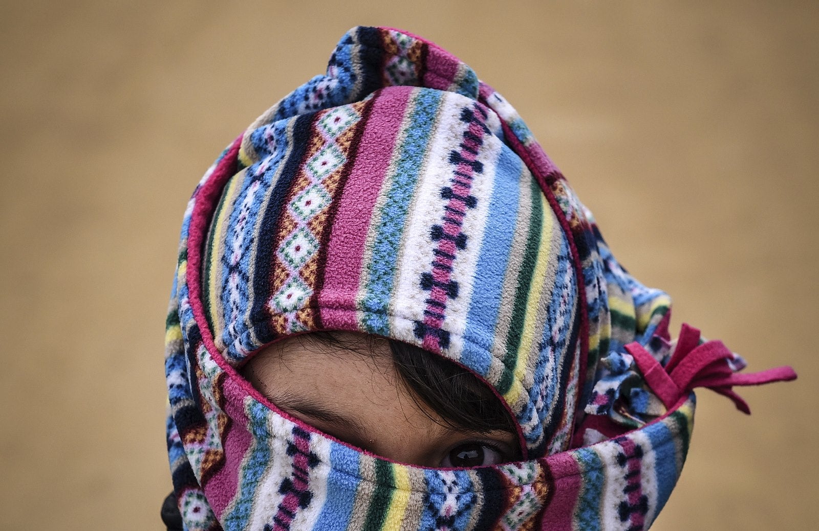 Un niño cubre su rostro después de cruzar la frontera entre Macedonia serbia.