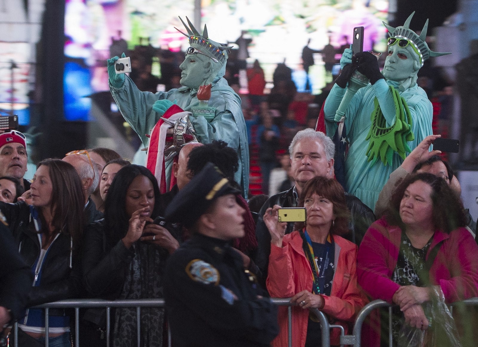 Personas disfrazadas de la Estatua de la Libertad, ven la caravana del presidente de Estados Unidos Barack Obama en Times Square.