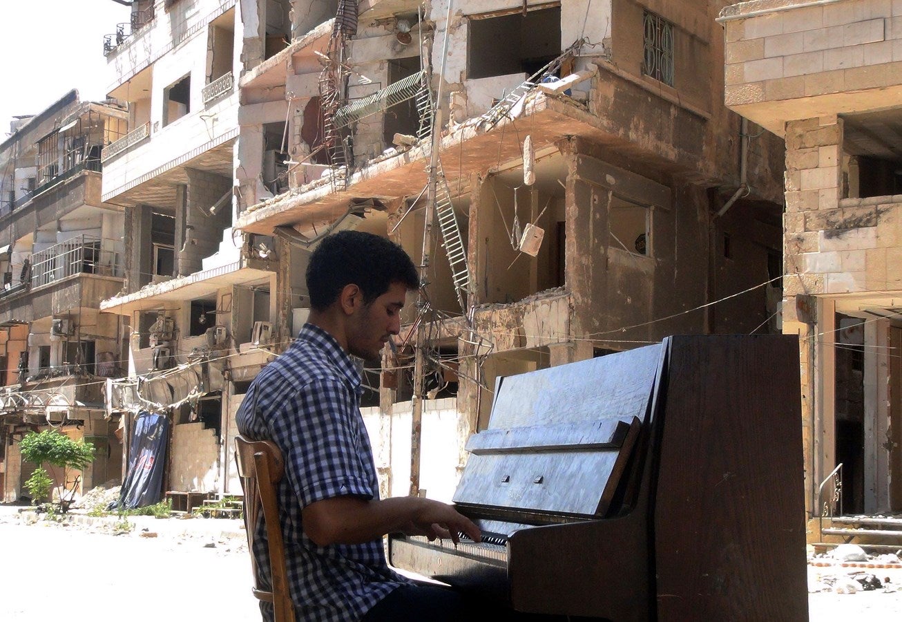 Rana Moussaoui Ayham al-Ahmed, residente en el campo de refugiados palestinos de Yarmuk de Damasco, toca el piano en el medio de la calle, cerca de los edificios destruidos.