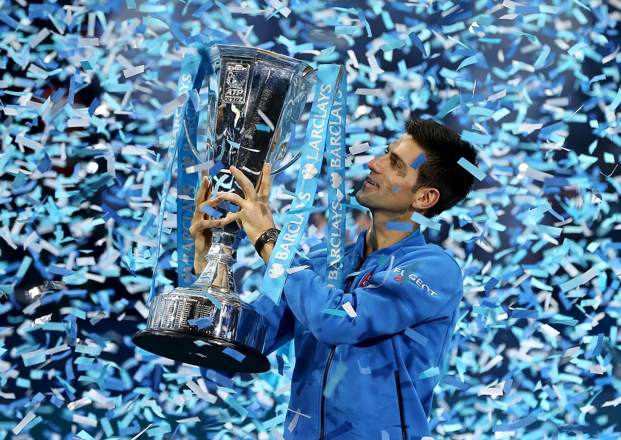 El serbio Novak Djokovic celebra con el trofeo después de ganar el ATP World Tour Finals Barclays contra Roger Federer.