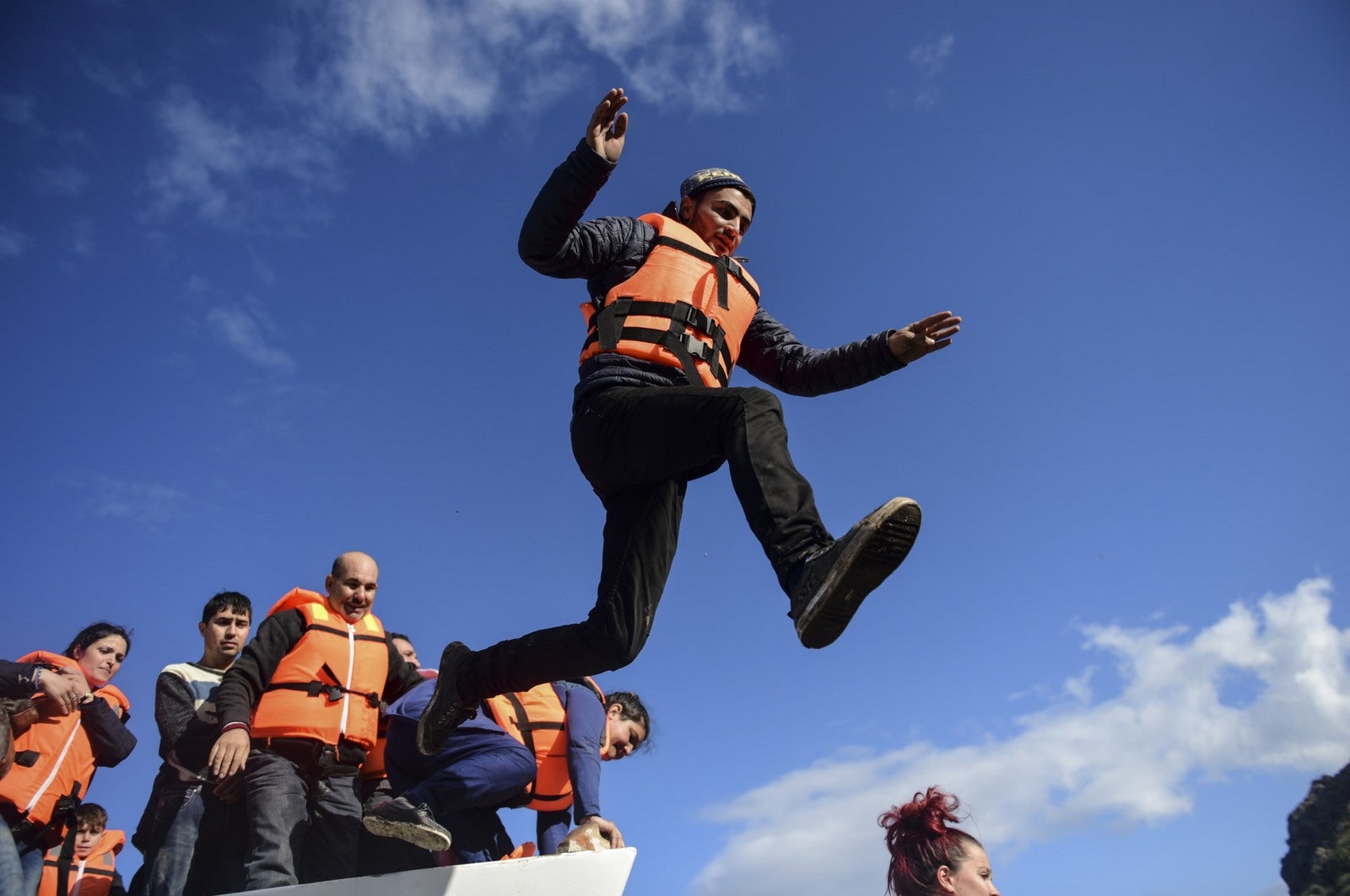 Un hombre salta desde una barca al llegr a la isla griega de Lesbos después de cruzar el Mar Egeo de Turquía.