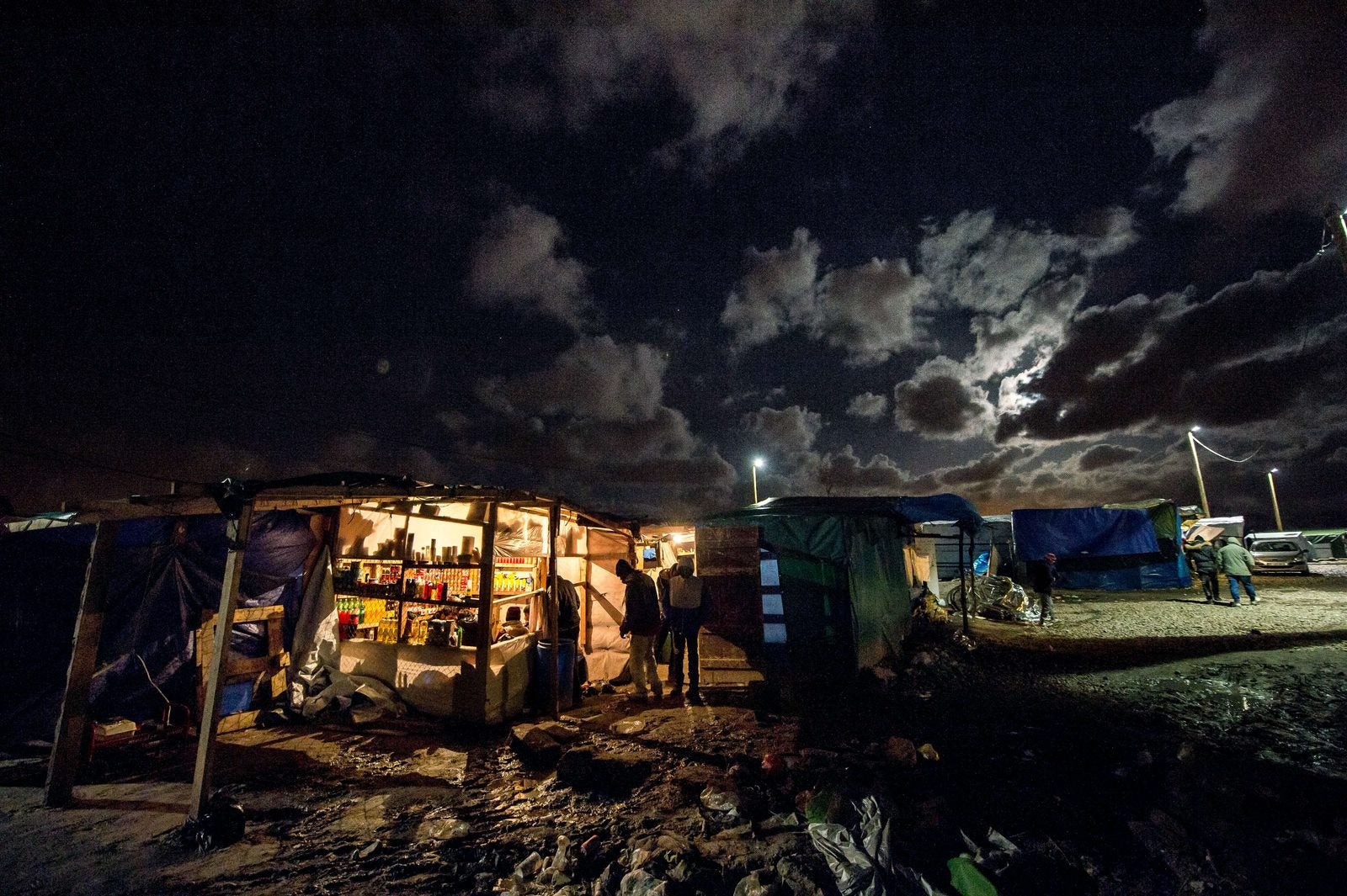 Refugiados se reúnen dentro de la "selva" de refugiados improvisado campamento.