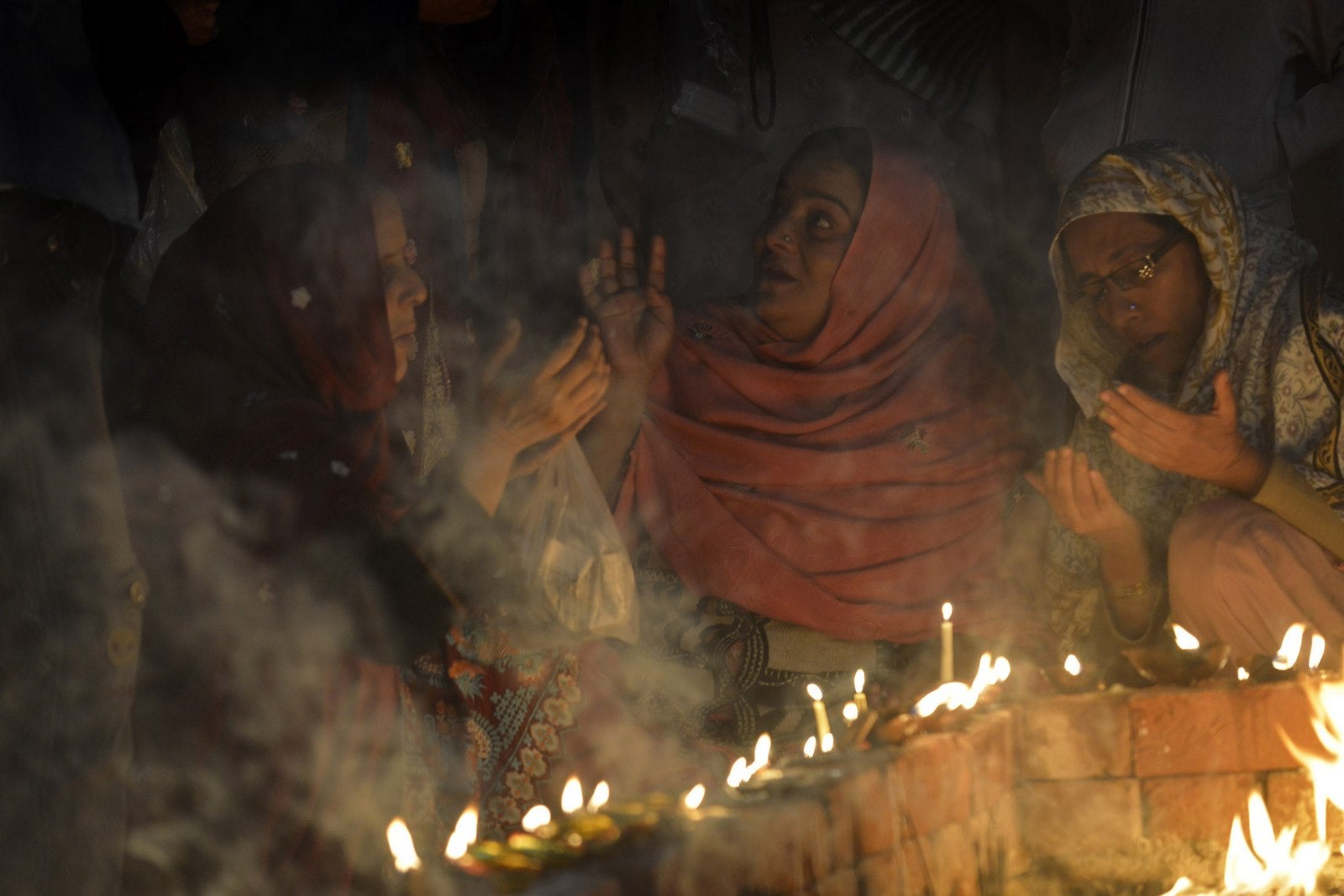 Devotos paquistanís musulmanes encienden velas y lámparas de aceite en el santuario del santo sufí Mian Mir Sahib con motivo de su aniversario de la muerte en Lahore.