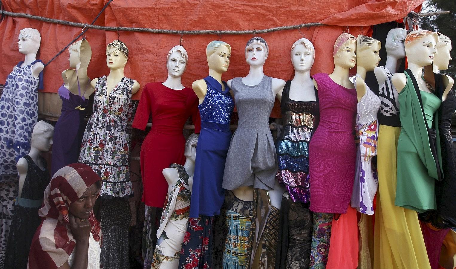 Una mujer pasa junto a una exhibición de ropa para la venta en "El Mercato" (el mercado) en Addis Abeba .