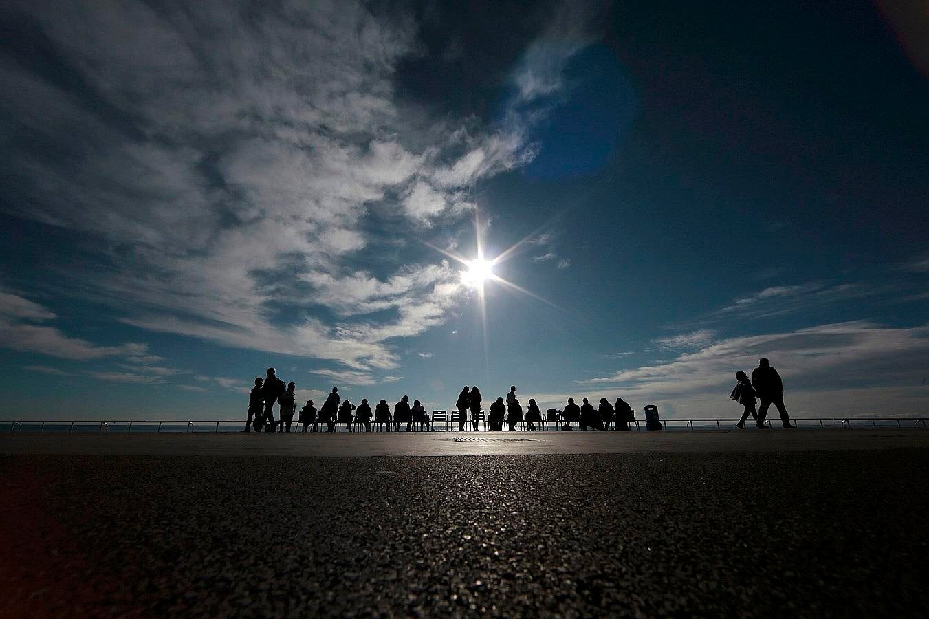 Un grupo de personas disfrutan de un día soleado de invierno en la Promenade des Anglais en Niza, Francia.