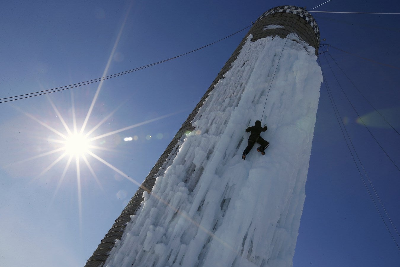 Un escalador asciende un silo cubierto de hielo en Cedar Falls, Iowa, Estados Unidos.