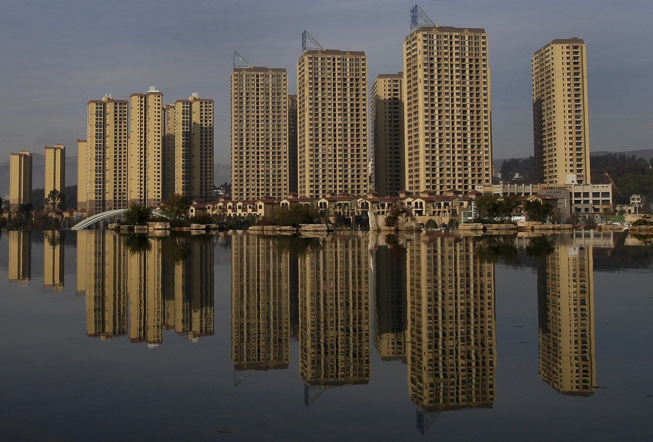 Edificios residenciales de nueva construcción se reflejan en un lago artificial en Kunming Cascada Park, provincia de Yunnan, China.