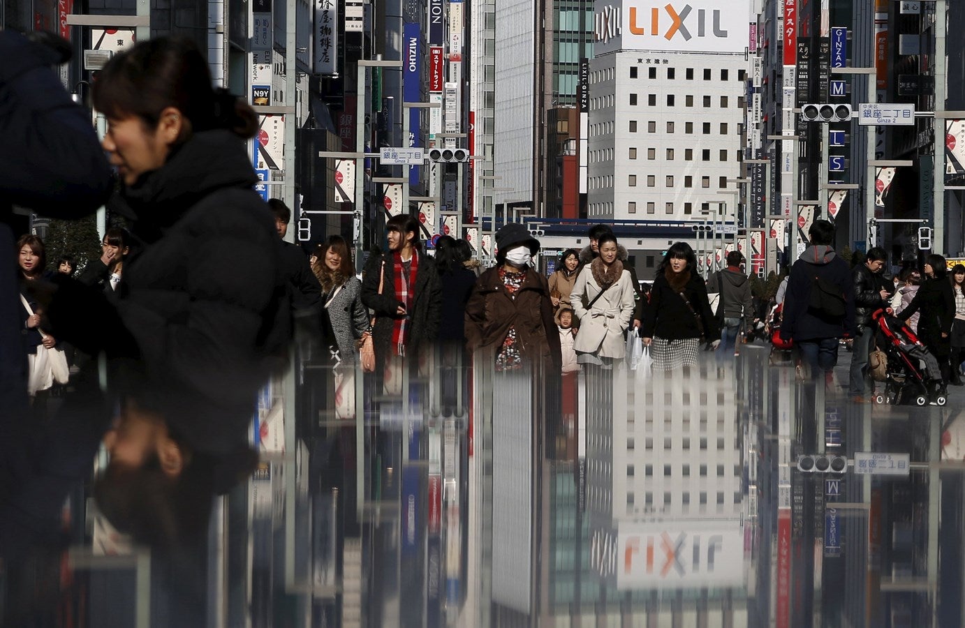 La gente camina en una calle en el distrito comercial de Ginza en Tokio .