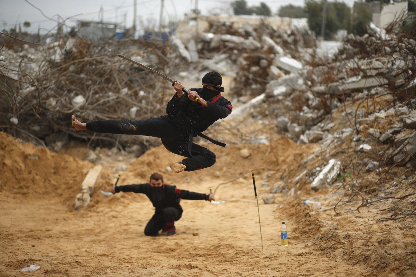 Un joven palestino salta con una espada mientras demuestra sus habilidades al estilo del ninja para el fotógrafo. .