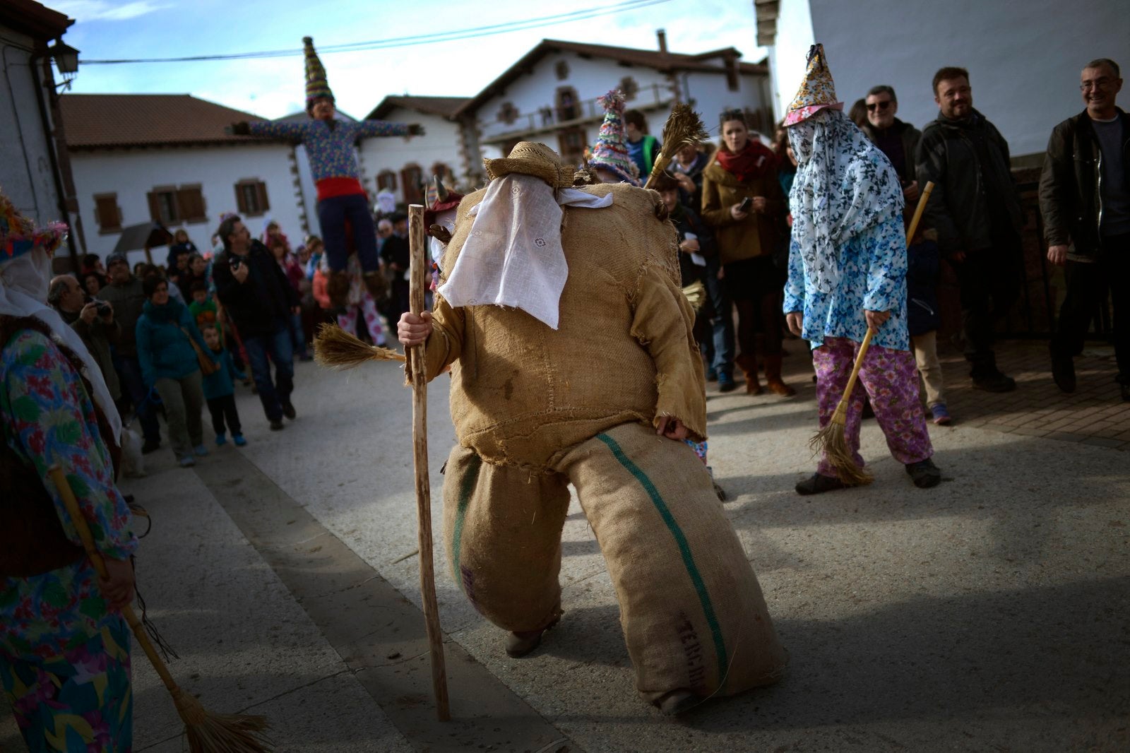 Una persona vestida como Ziripot, una figura tradicional relleno de paja, camina delante de la figura de Miel Otxin durante las celebraciones de carnaval en la localidad navarra de Lantz.