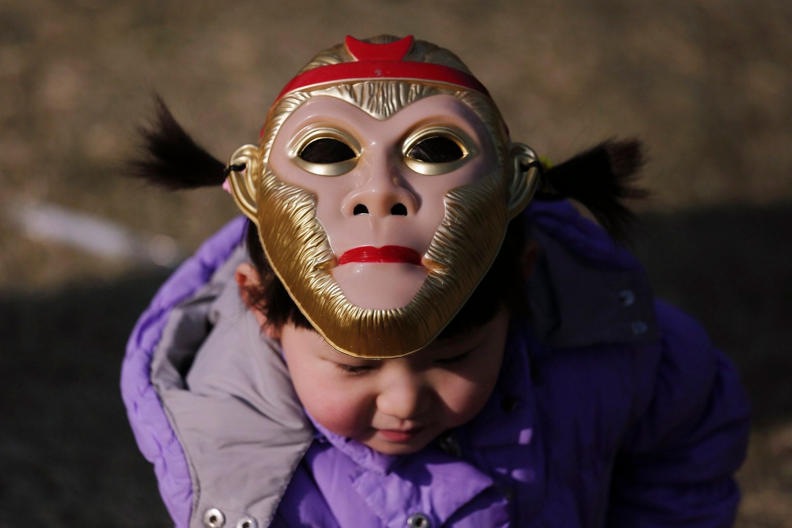 Una chica llevaba una máscara de mono encima de su cabeza, en el Año Nuevo Lunar chino, que da la bienvenida al año del mono, se celebra en Beijing, China.