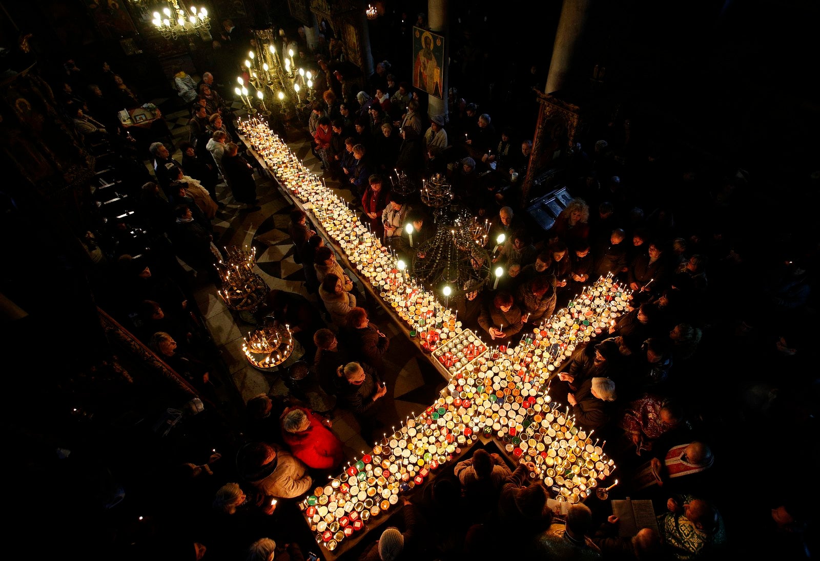 Los fieles se reúnen alrededor de las velas pegadas en frascos con miel, durante una misa religiosa en la iglesia de la Presentación de la Virgen en Blagoevgrad, Bulgaria.