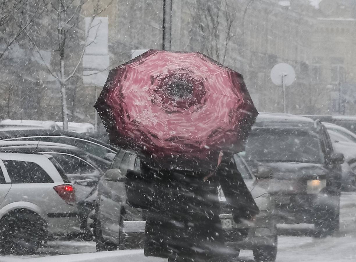 Una mujer camina con un paraguas a lo largo de una calle durante una nevada en el centro de Kiev, Ucrania.