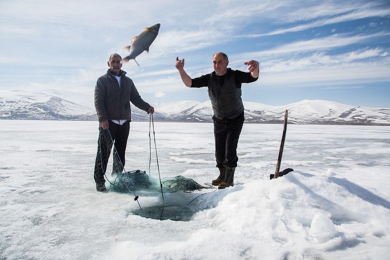 Un pescador lanza un pez fuera de las aguas congeladas del "Lago Cildir" en Ardahan Provincia de Turquía.