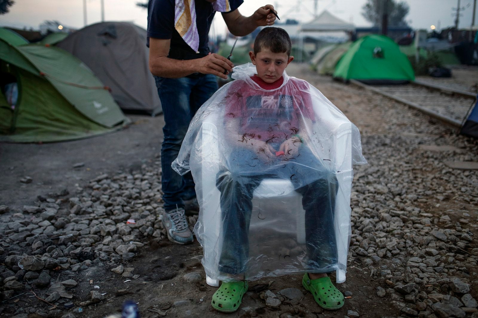 Un niño se corta el pelo en un campamento improvisado en la frontera entre Grecia y Macedonia, cerca de la localidad de Idomeni, Grecia