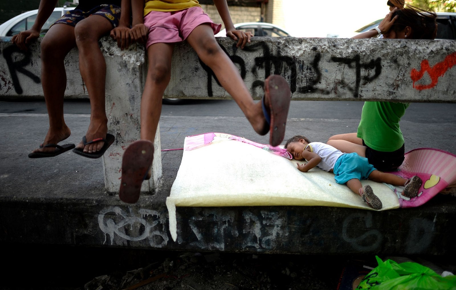 Un niño duerme en un puente en Manila