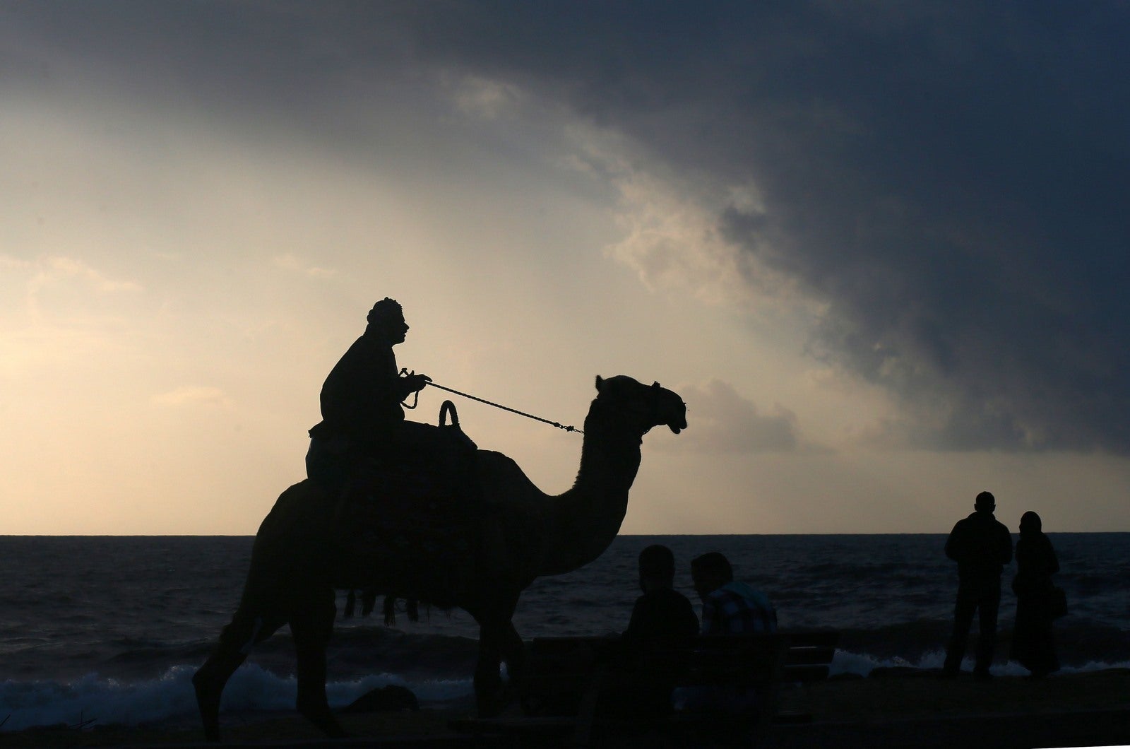 Un palestino monta un camello al atardecer en la playa, en la ciudad de Gaza, el 13 de abril de 2016.