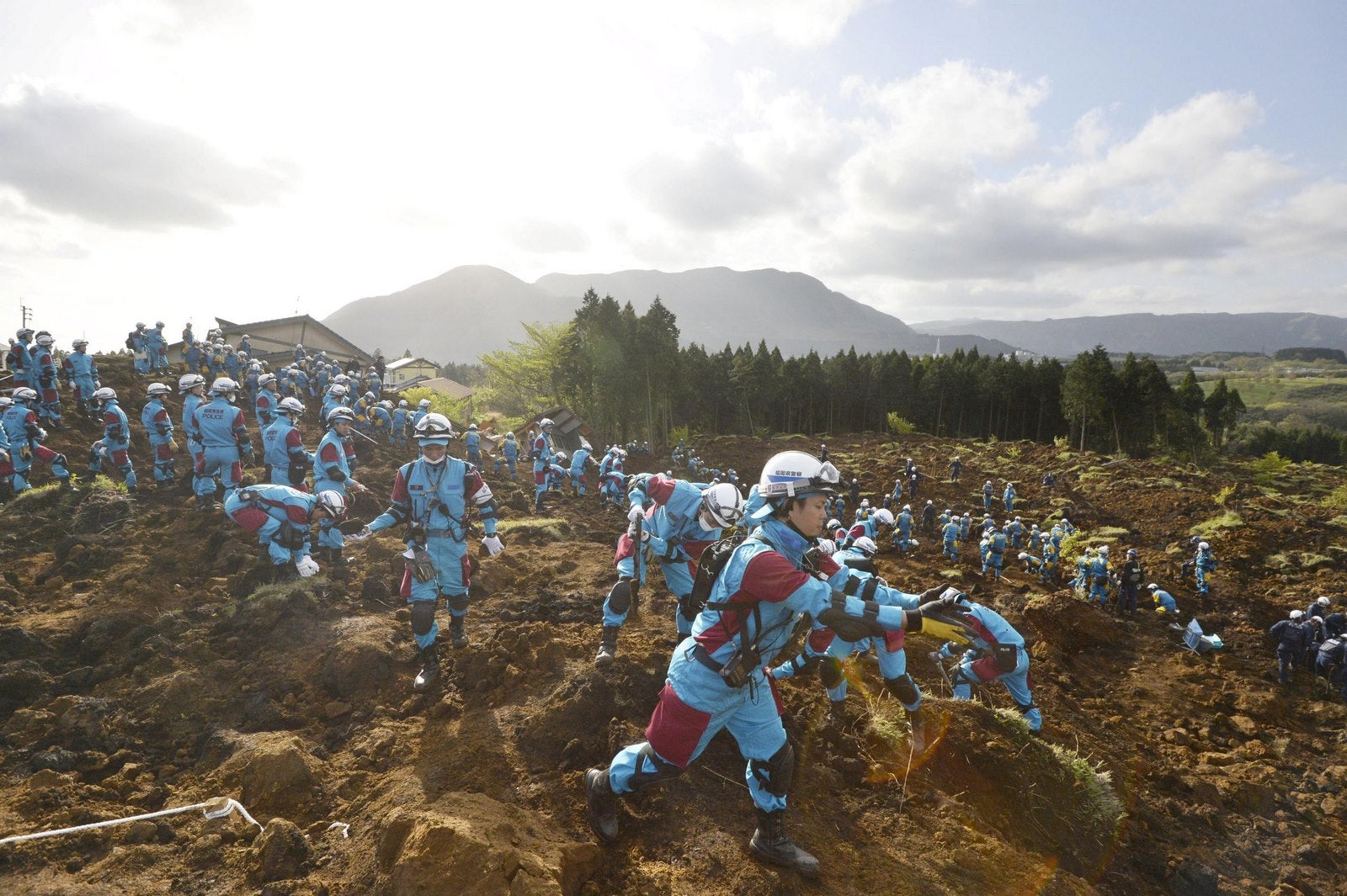 Los agentes de policía llevan a cabo una operación de búsqueda y rescate a una casa derrumbada en un sitio de deslizamiento de tierra causado por los terremotos en la ciudad de Minamiaso, prefectura de Kumamoto, el sur de Japón